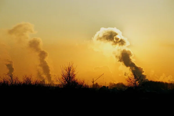 smoke from factory chimneys over sunset