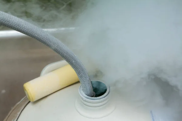 Close up of container with liquid nitrogen,Cold metal pipe smoking from transferring liquid nitrogen