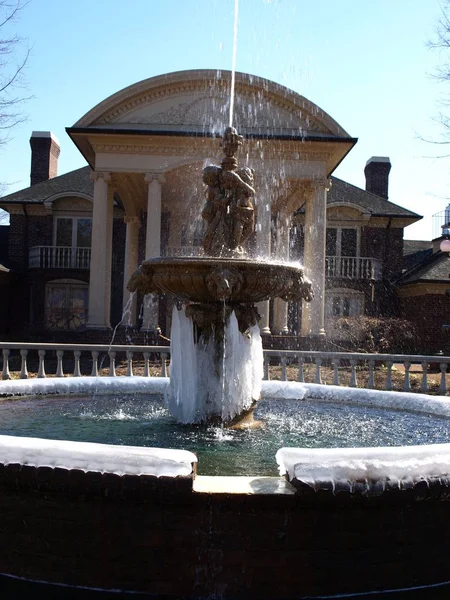 Una Fontana Ghiacciata Fronte Una Grande Casa — Foto Stock