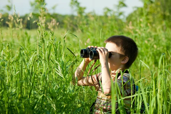 双眼鏡を通して見ている分野の若い男の子 — ストック写真