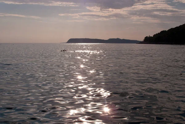 Háttérvilágítással Sziluettje Magányos Úszó Egy Öbölben Nap Süt Tükrözi Hullámok — Stock Fotó