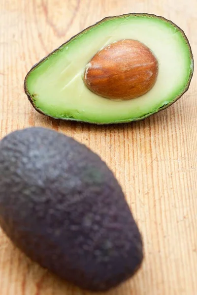 Mezzo Avocado Con Pietra Una Tavola Legno — Foto Stock