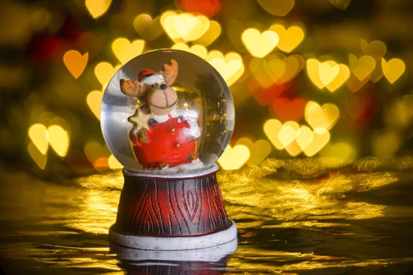 Weihnachten Schneekugel Mit Weihnachtsbeleuchtung Hintergrund Rentiere Weihnachtsmann Kleidung Herzformen Bokeh — Stockfoto