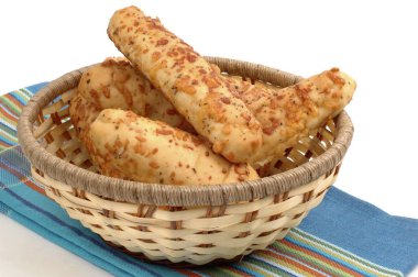 Fresh baked garlic and cheese breadsticks in a basket. clipart
