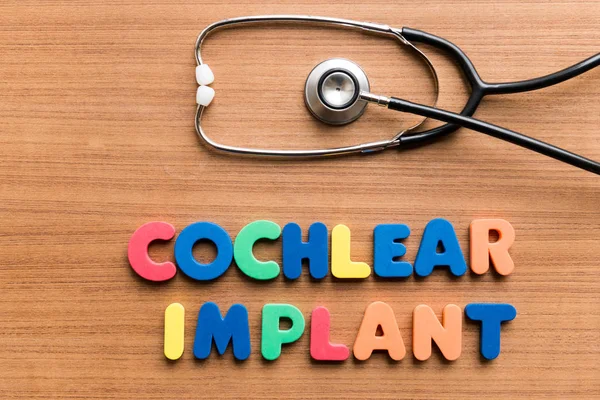 Implante Coclear Palavra Colorida Com Estetoscópio Sobre Fundo Madeira — Fotografia de Stock