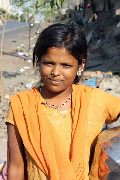 A portrait of a poor Indian teenage girl in a traditional attire, on the roadside.