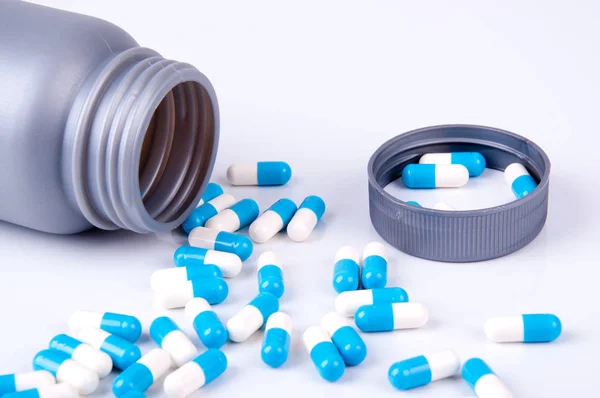 青と白のカプセルに薬を入れたプラスチック容器 — ストック写真