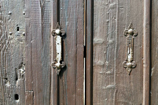 カステランザブラーロンバルディ抽象的な錆びた真鍮のノッカーは ドアの湾曲した木製イタリアの十字架を閉じました — ストック写真
