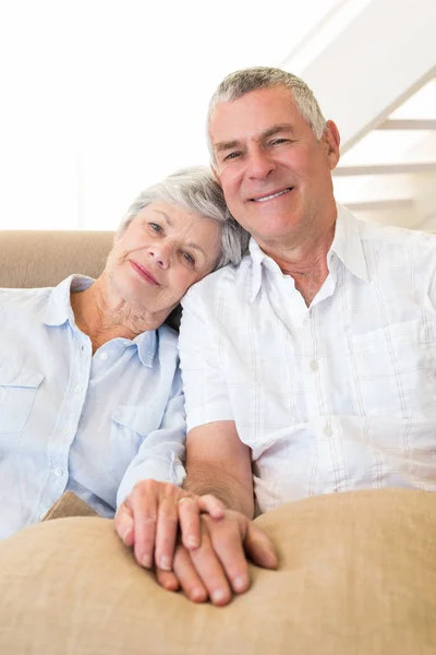 Pensionato Coppia Che Tiene Mano Sul Divano Sorridente Alla Fotocamera — Foto Stock