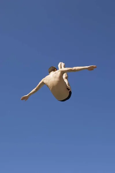 Man diving in pike position, mid air