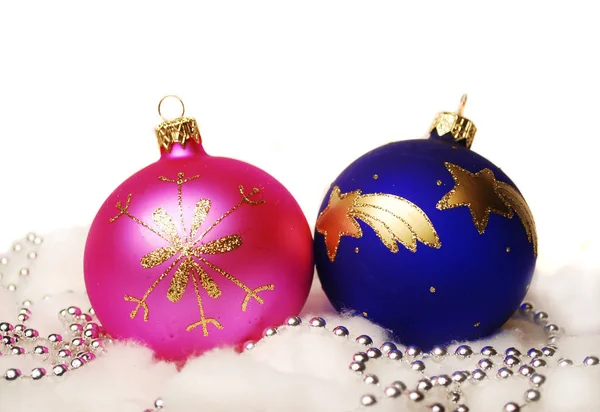 白い背景にピンク 青と金のクリスマスボールと銀のチェーン — ストック写真