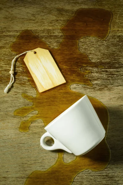 从一个白色的杯子洒咖啡在一个格子桌子上 有文字空间 — 图库照片