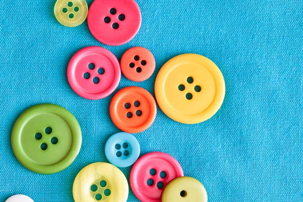 Kleurrijke Plastic Knoppen Blauw Textiel Als Achtergrondafbeelding — Stockfoto