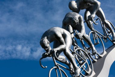 Three cyclists in a downhill, part sculpture clipart