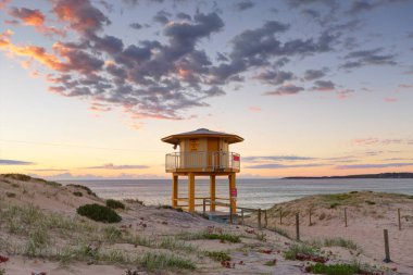 Wanda Beach Lifeguard lookout tower with sunrise skies clipart