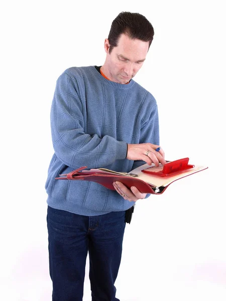 一个穿着蓝色衣服的成年男性检查了活页夹中的一些数字 在白色背景上隔离 — 图库照片