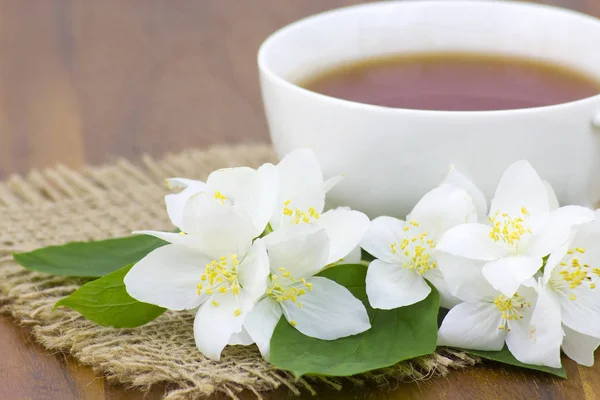 Cup of jasmine tea and jasmine flowers