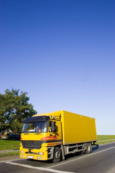 沥青路上的黄色卡车 大蓝天与复制文本的位置 — 图库照片