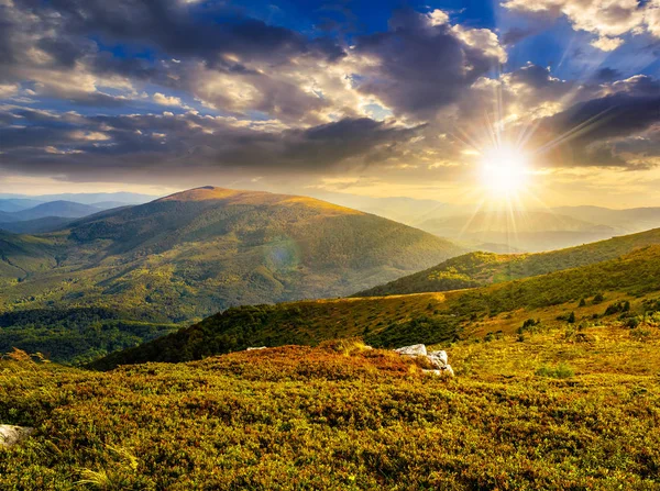 夕方の光の高い山脈の丘の端に草原の草地に白い鋭い岩 — ストック写真