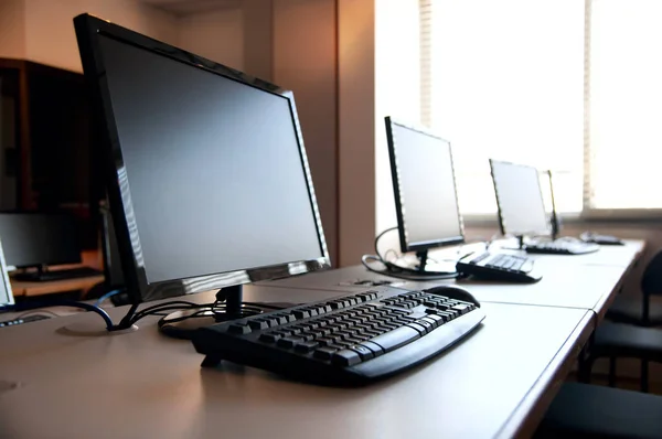 Row of desktop PCs workplaces in the classroom