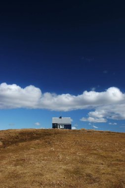 Isolated house on a hill in the countryside clipart