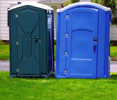Two portable bathrooms on a cloudy overcast day clipart