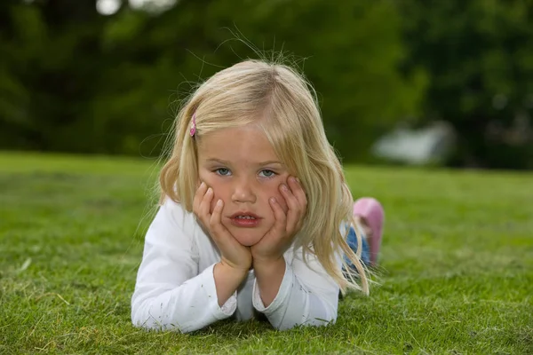 草の上に横たわっているかわいい4歳の女の子 — ストック写真