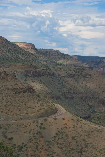 Huge Desert Cliffs Loom Winding Highway Road Swirling White Clouds — Stock Photo, Image