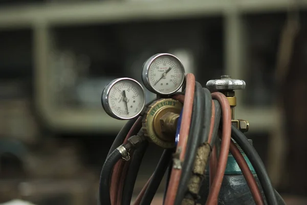 Top of industrial oxygen bottle with valve and pressure gauge. Shallow depth of field.