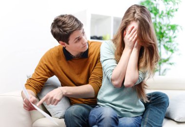Young anxious couple quarrels by consulting their bank account clipart