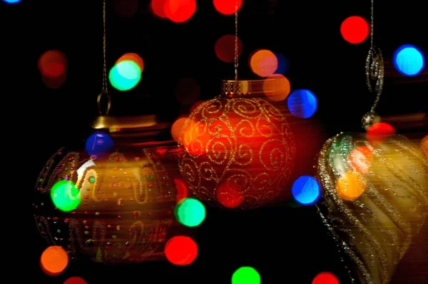 Bauble Natal Ornamentado Pendurado Contra Fundo Preto Com Luzes Coloridas — Fotografia de Stock