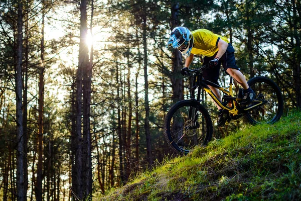 黄色のTシャツとヘルメットのプロのサイクリストは 森の中で自転車ダウンヒルに乗ります エクストリームスポーツコンセプト — ストック写真