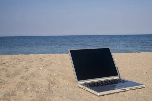 Laptop Sitter Sand Med Hav Och Blå Himmel Bakom — Stockfoto