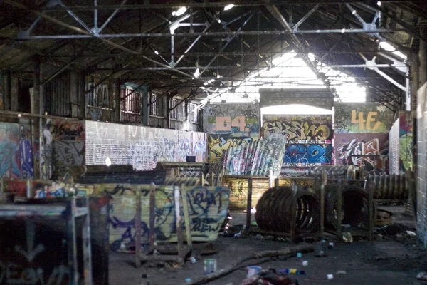 An old abandoned area that has been converted to a paint ball course.  Every inch is covered with graffiti.
