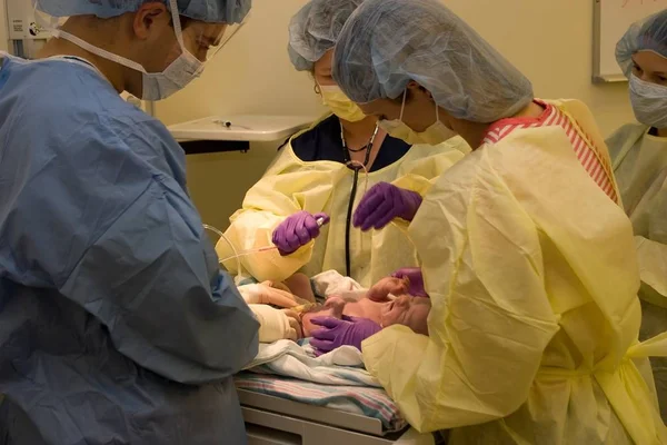 Πενεοτινοί Εξετάζουν Νεογέννητο Στο Χειρουργείο Κατά Διάρκεια Της Τομής — Φωτογραφία Αρχείου