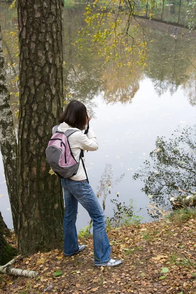 バックパックを持つ女の子は 湖に人を費用がかかります — ストック写真