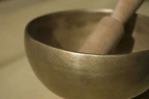 Tibetan singing bowl with mallet on table