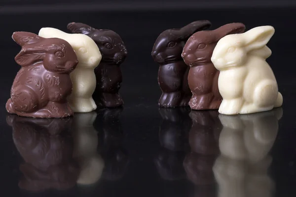 Deliciosos Coelhos Páscoa Chocolate Uma Fileira Fundo Preto Com Reflexão — Fotografia de Stock