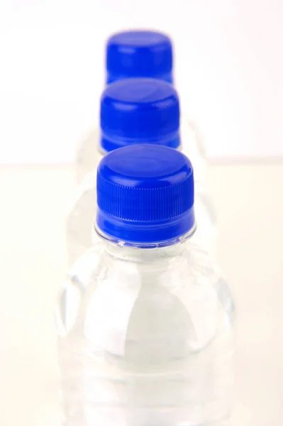 Flaskvatten Isolerat Mot Olika Bakgrunder — Stockfoto