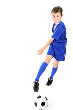 Child kicking or manoeuvring a soccer ball.  Motion to ball and kicking foot. clipart