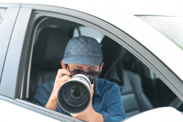Private Detective Sitting Inside Car Doing Surveillance Work Photographing With Camera