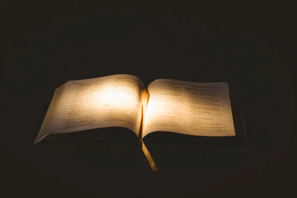 Luz Que Brilla Sobre Biblia Abierta Sobre Fondo Negro — Foto de Stock