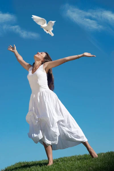 The happy woman releasing a pigeon in sky