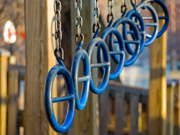 Rings on a jungle gym in a city shoolyard.