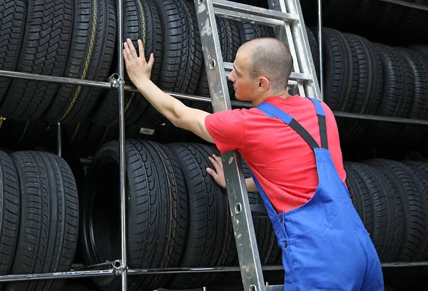 Ein Motivierter Arbeiter Einer Reifenwerkstatt Der Auf Einer Leiter Steht — Stockfoto