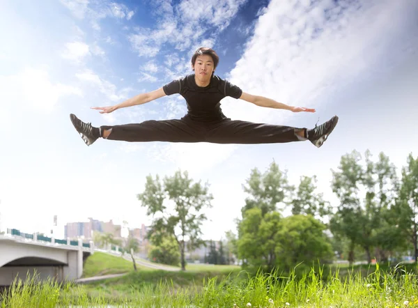Mladý Muž Skákání Vzduchu Nedaleko Mostu Jasné Oblohy — Stock fotografie