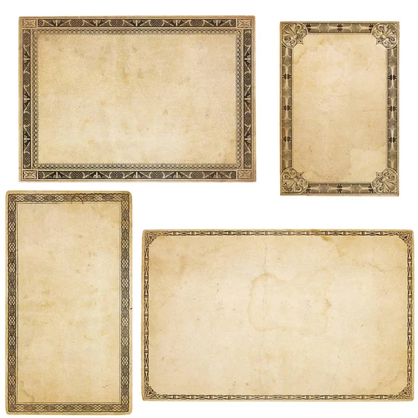 A set of four heavily aged blank cards with stains, creases and tears.  Each card has different, old-fashioned decorative border. Isolated on white. Includes clipping paths.