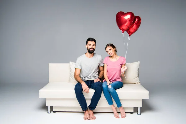 Pareja Sentada Sofá Blanco Con Globos Rojos Forma Corazón — Foto de Stock