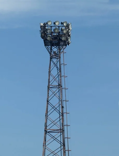 Προβολείς Στην Κορυφή Ενός Πύργου Χάλυβα Ένα Γαλάζιο Φόντο Του — Φωτογραφία Αρχείου