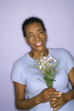 African American mature adult female holding flowers. clipart